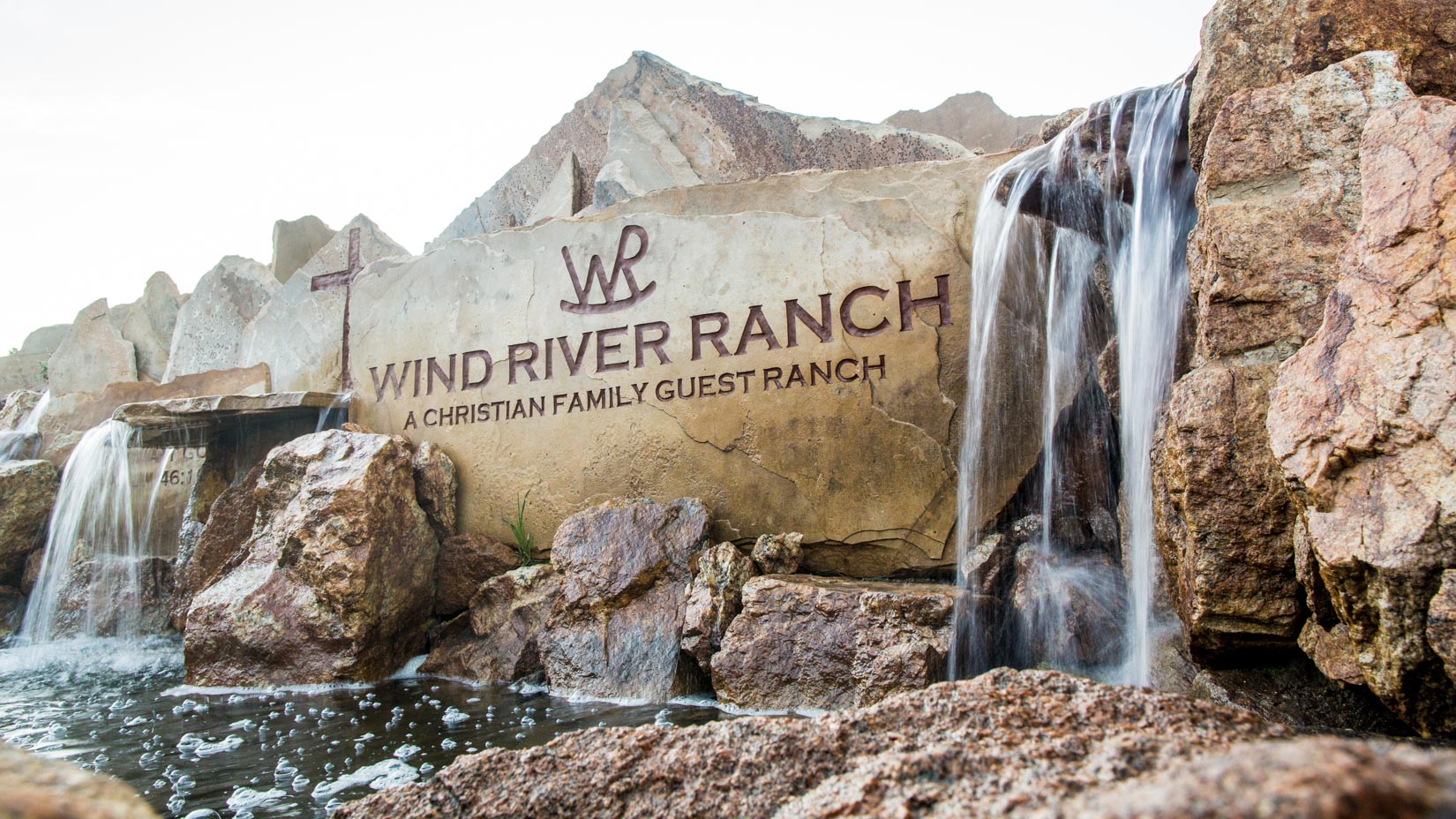 A sign at the welcome gate of the camp thats has Wind River Ranch engraved.